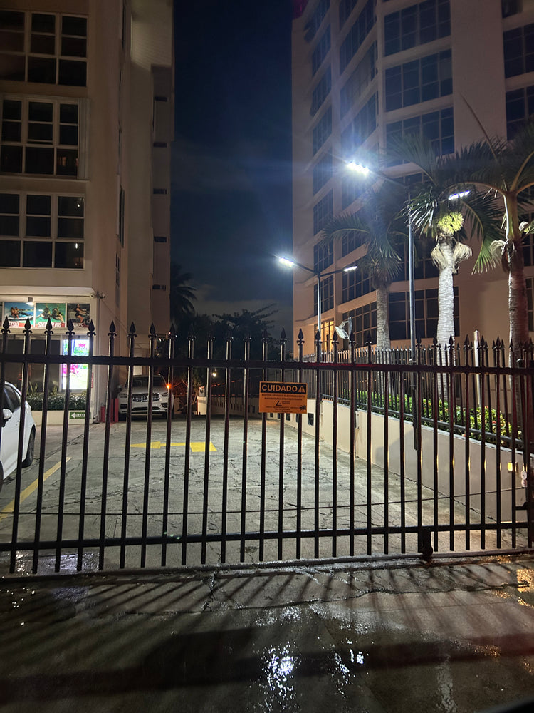 Lámparas solares LED de poste alumbrando el estacionamiento de un condominio