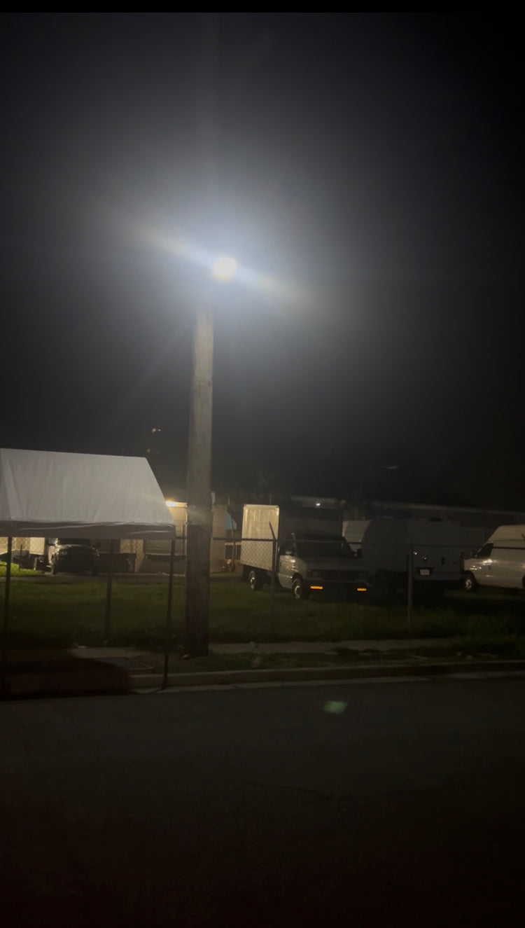 Lámpara solar LED en poste alumbrando un solar de noche